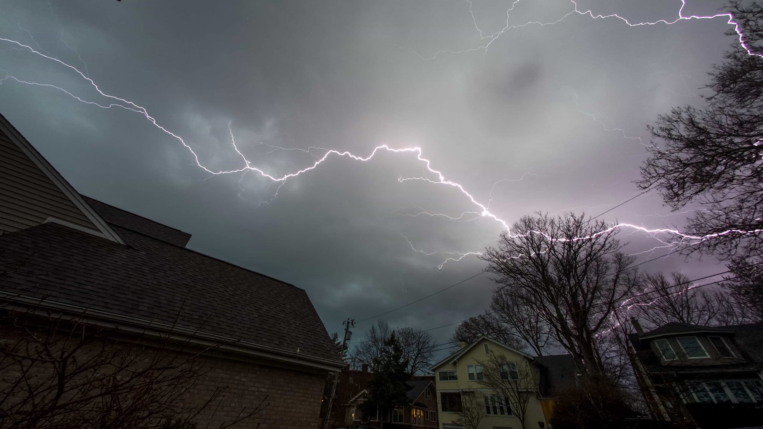 Lightning Damage Electrical Panel: Ultimate Ocala Safety Guide 1 A dramatic winter thunderstorm scene over a snowy landscape with a bright purple lightning damage electrical panel bolt striking down from dark storm clouds, emphasizing the need for lightning rod installation in Columbus, Ohio.